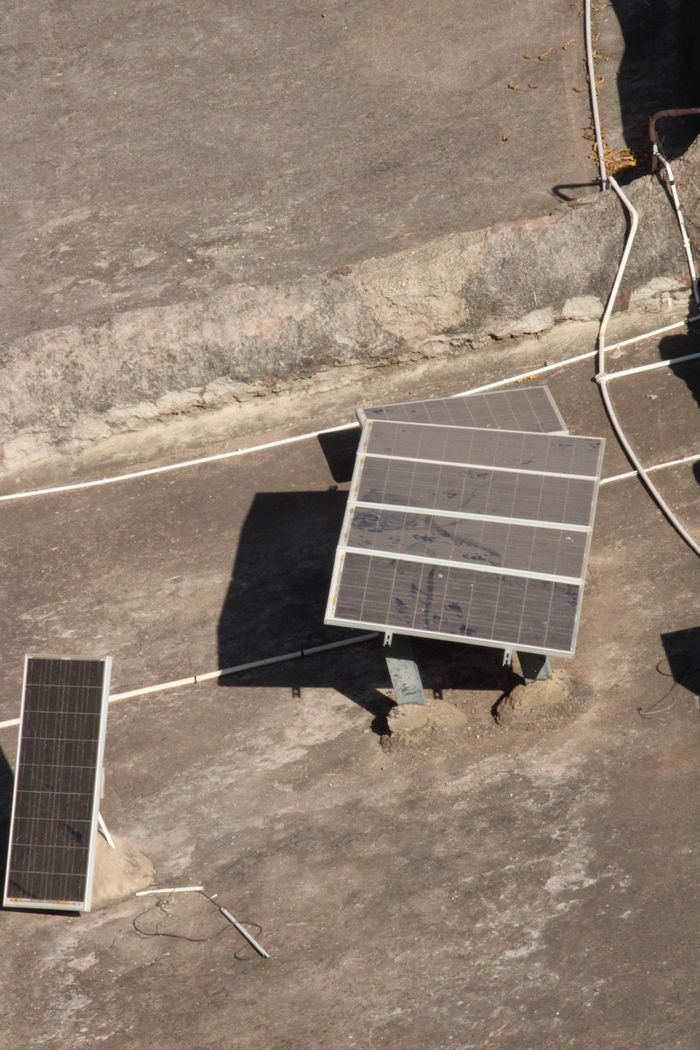 Crafting Captivating Headlines: Your awesome post title goes here Aerial shot of solar panels on a rooftop in Badami, India under bright sunlight.