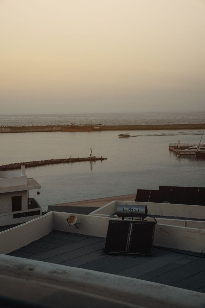Home Serene coastal scene at sunset featuring a rooftop solar panel and tranquil waters.