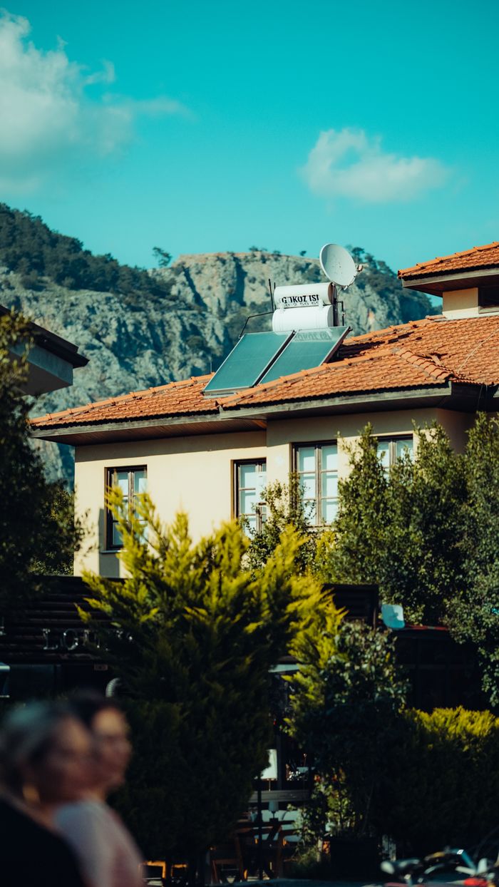 Home A picturesque urban house with solar panels and mountain view in the background.